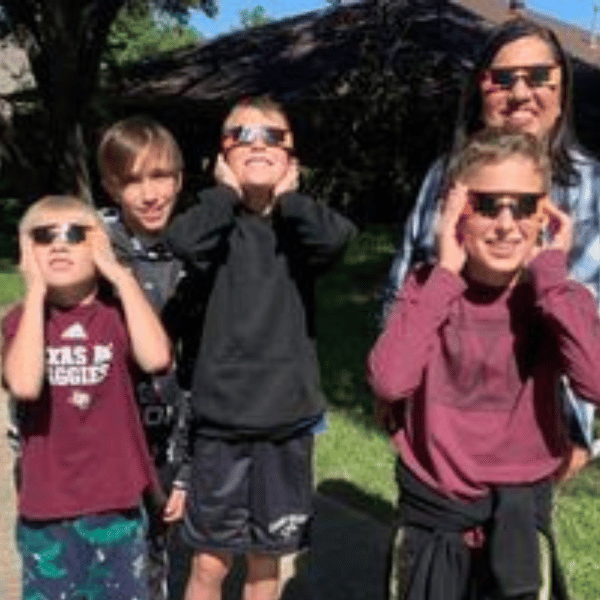 five children outside wearing total eclipse glasses