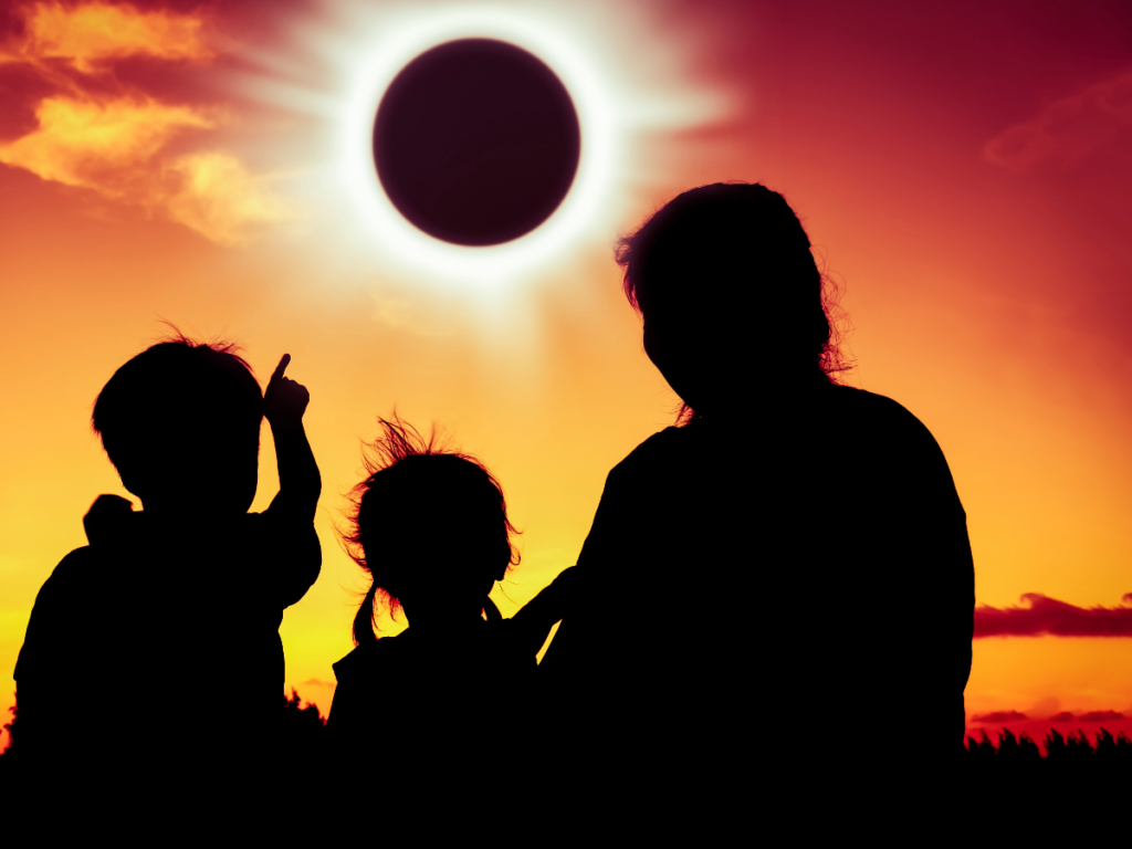 Mother and two children watching a solar eclipse