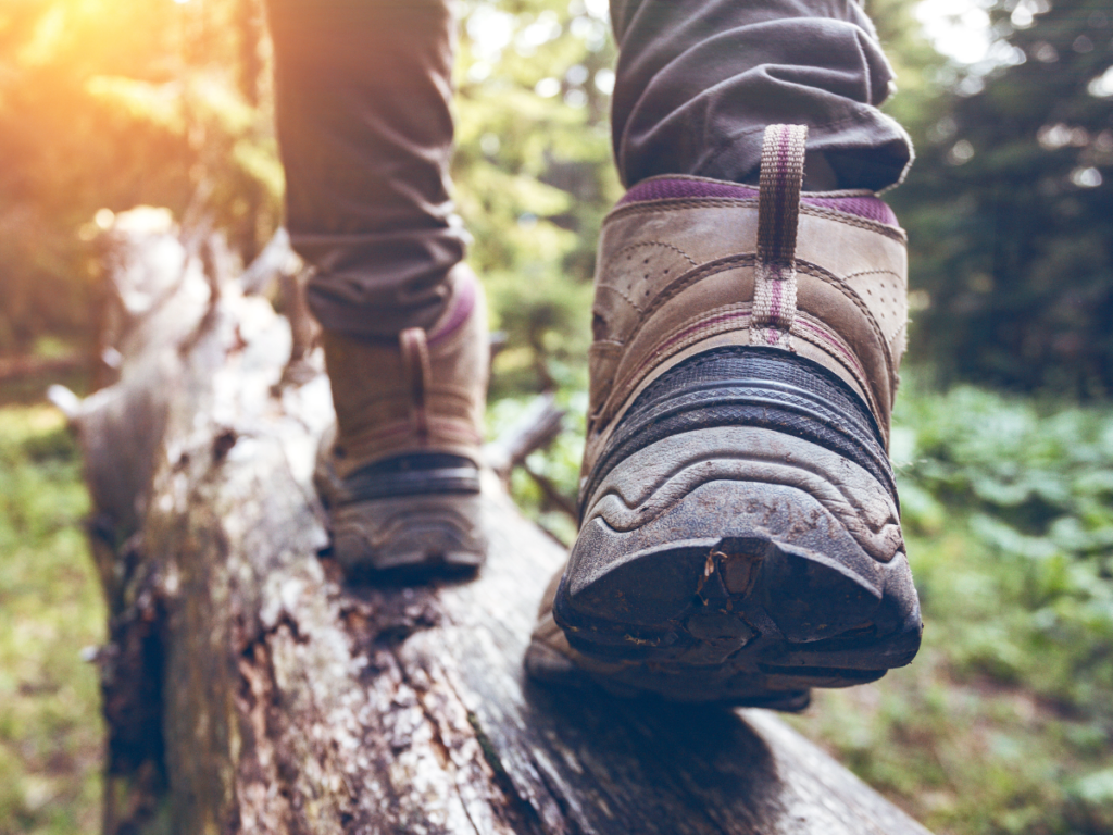 Man in hiking boots walking on a log