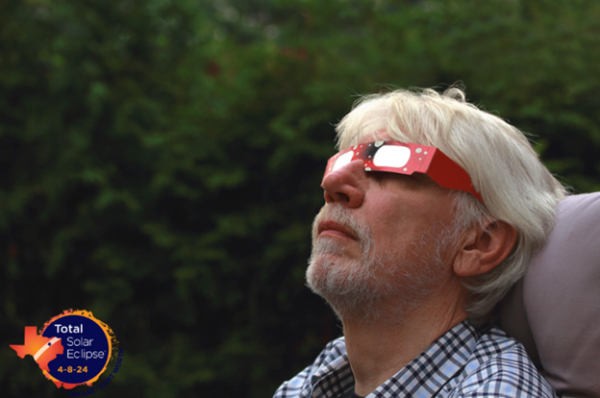 man outside with solar eclipse glasses on
