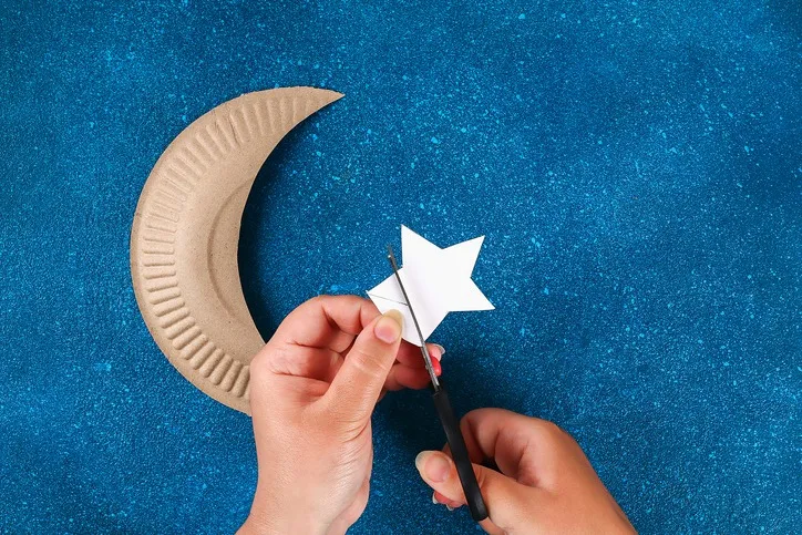 hands cutting paper star